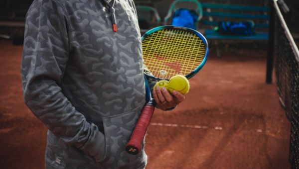 image of a person holding tennis racket and balls