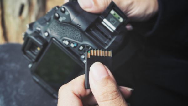 person inserting the sd card in camera