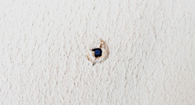 Image of a camera inside a wall hole