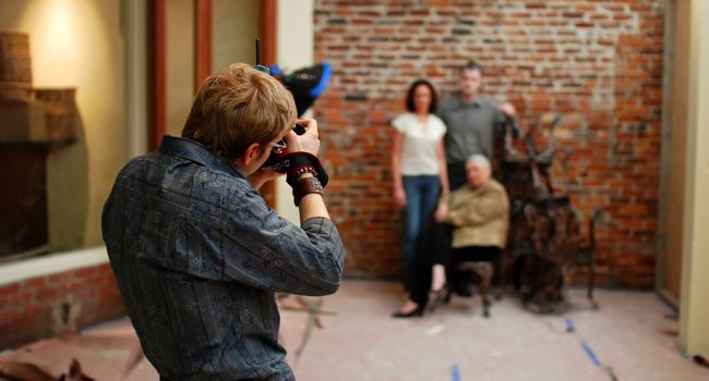 a photographer taking pictures of a three person family