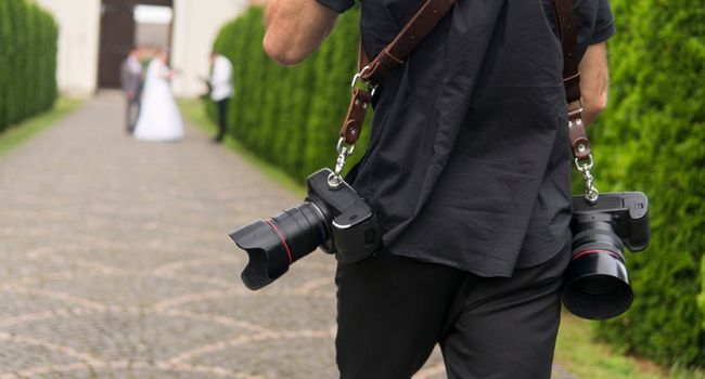 image of a person carrying two cameras