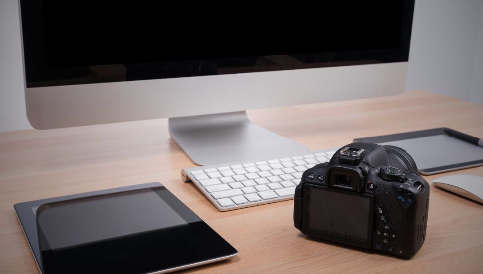 camera on desk alongside an iMac