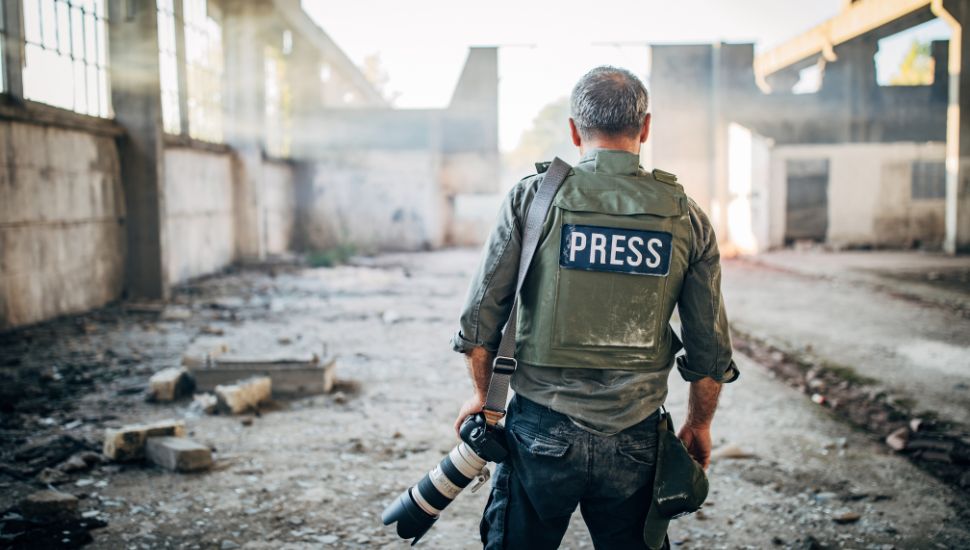 a journalist photographer standing in burned building