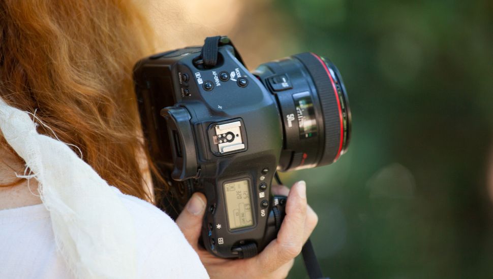 a person holding camera on her shoulder